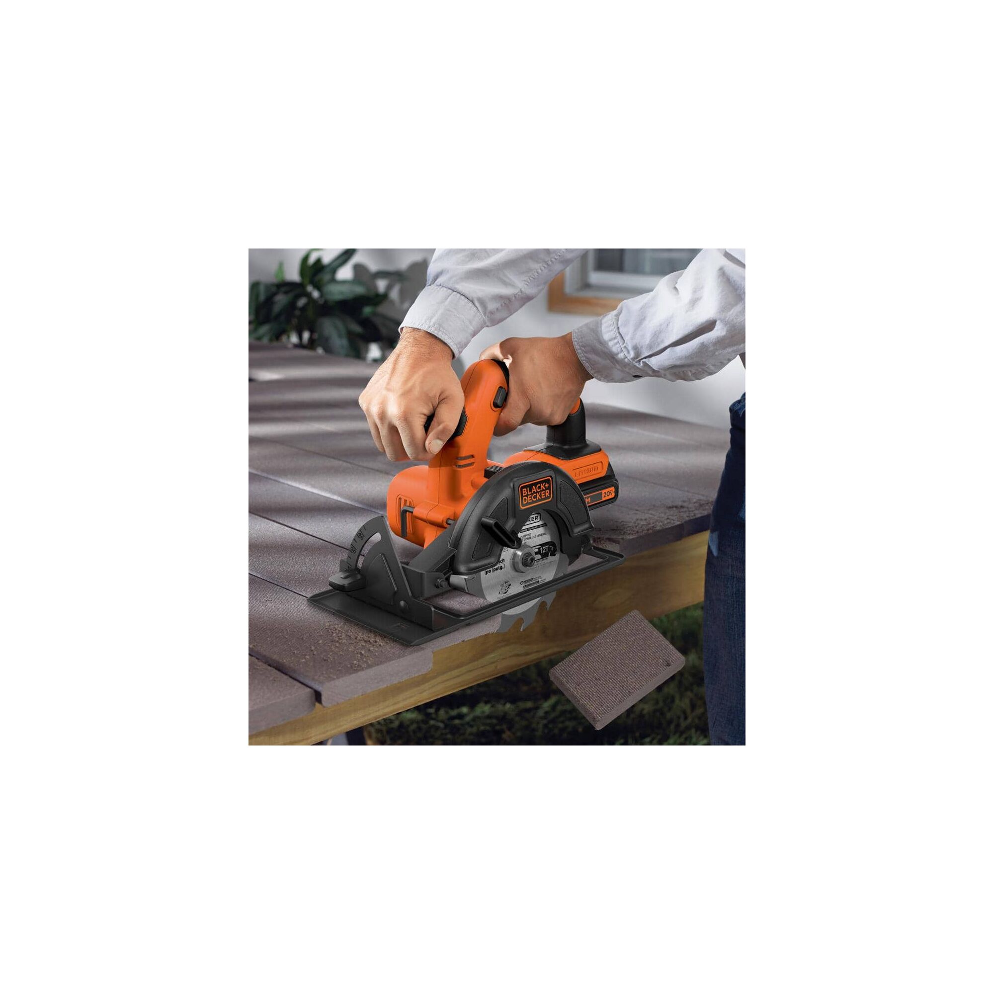 Cordless circular saw being used by person to cut wood