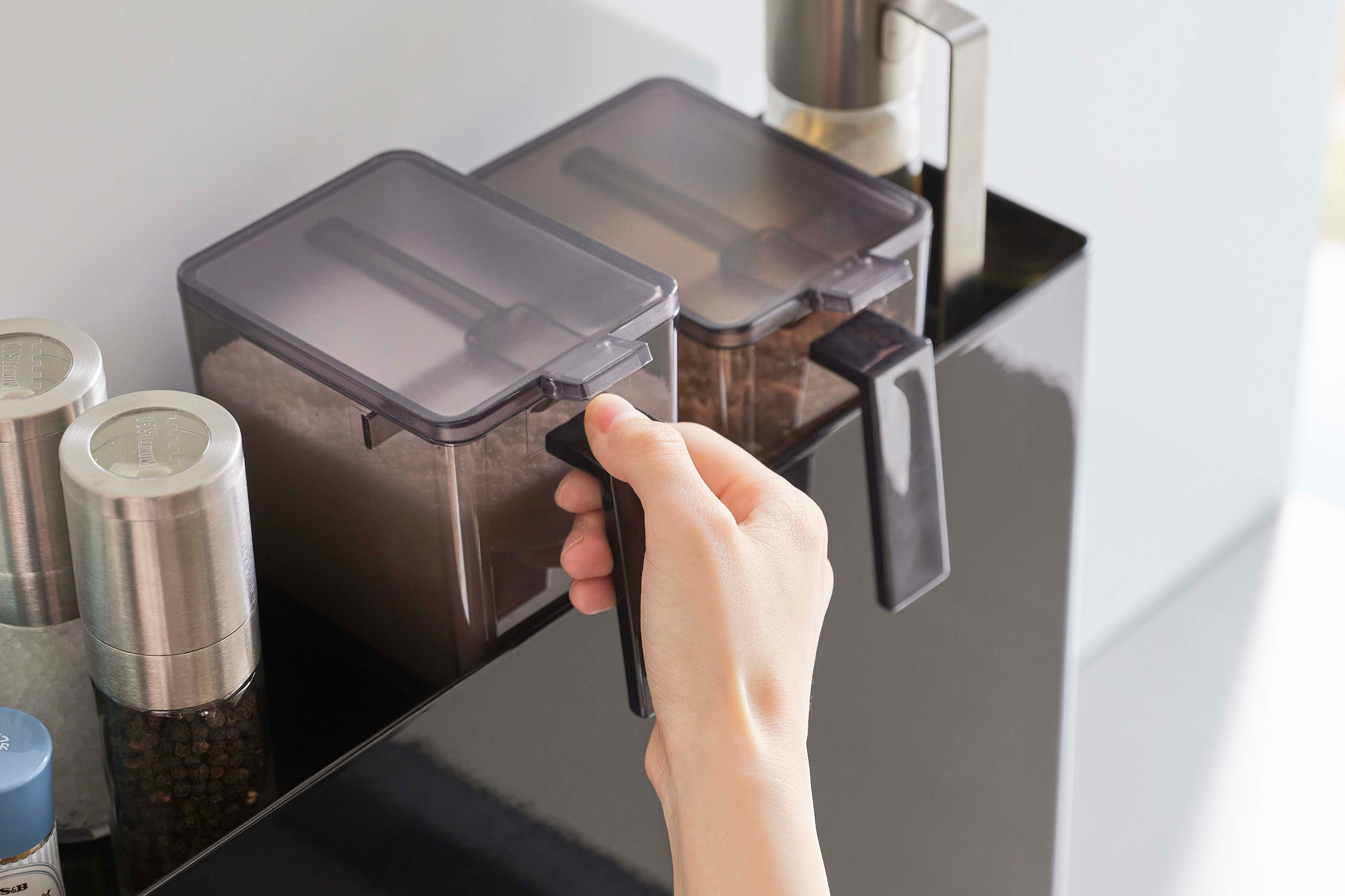 White Yamazaki Home Sliding Seasoning Rack on a stove counter open