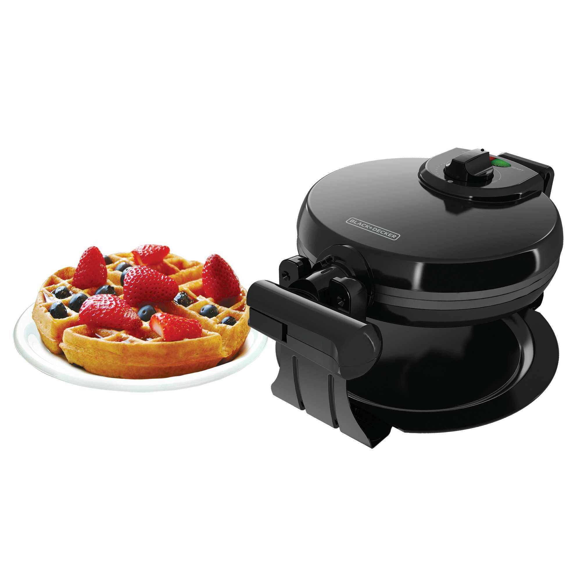 Belgian waffle maker with waffles and berries.