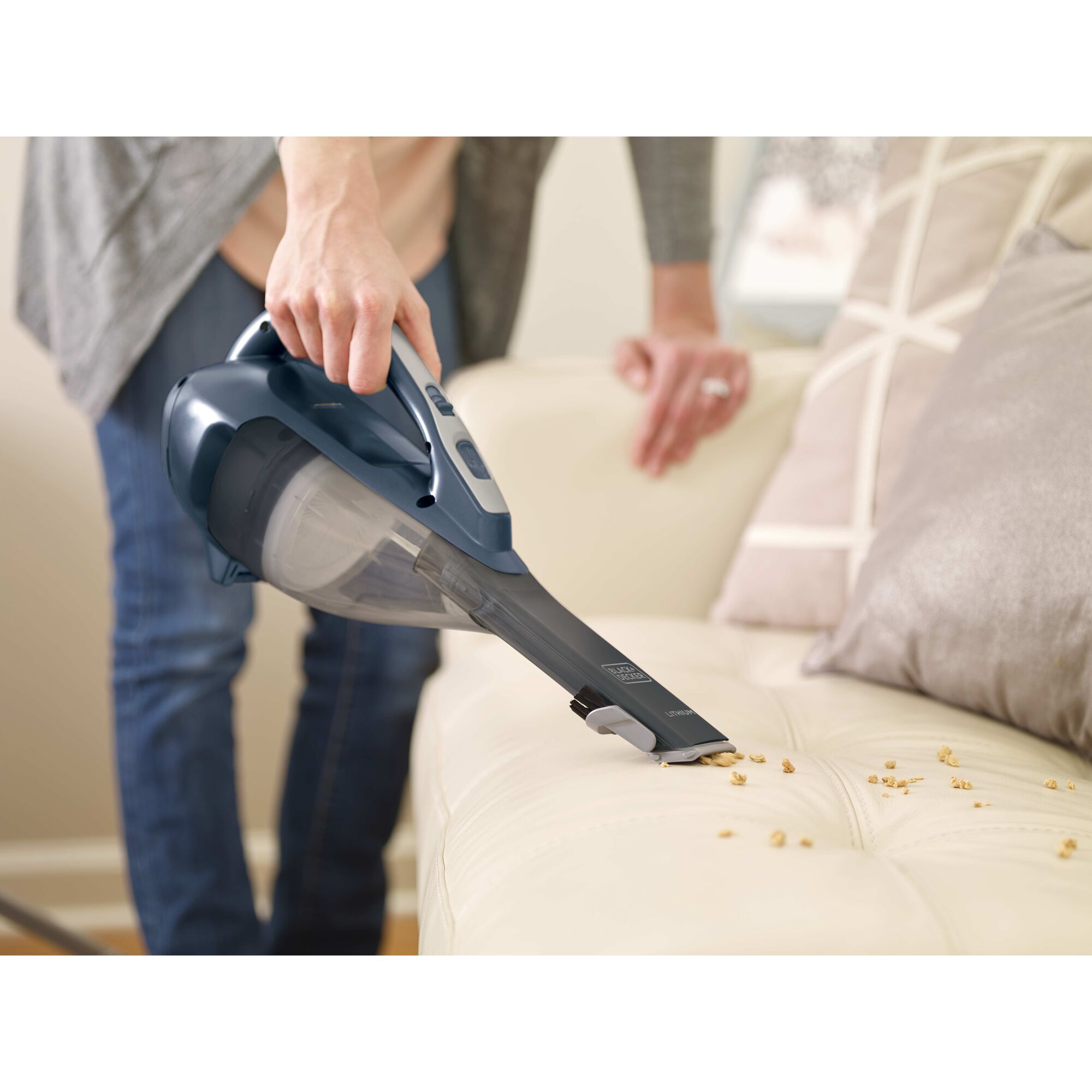Dustbuster Advanced Clean Cordless Hand Vacuum being used to pick up food bits from sofa.