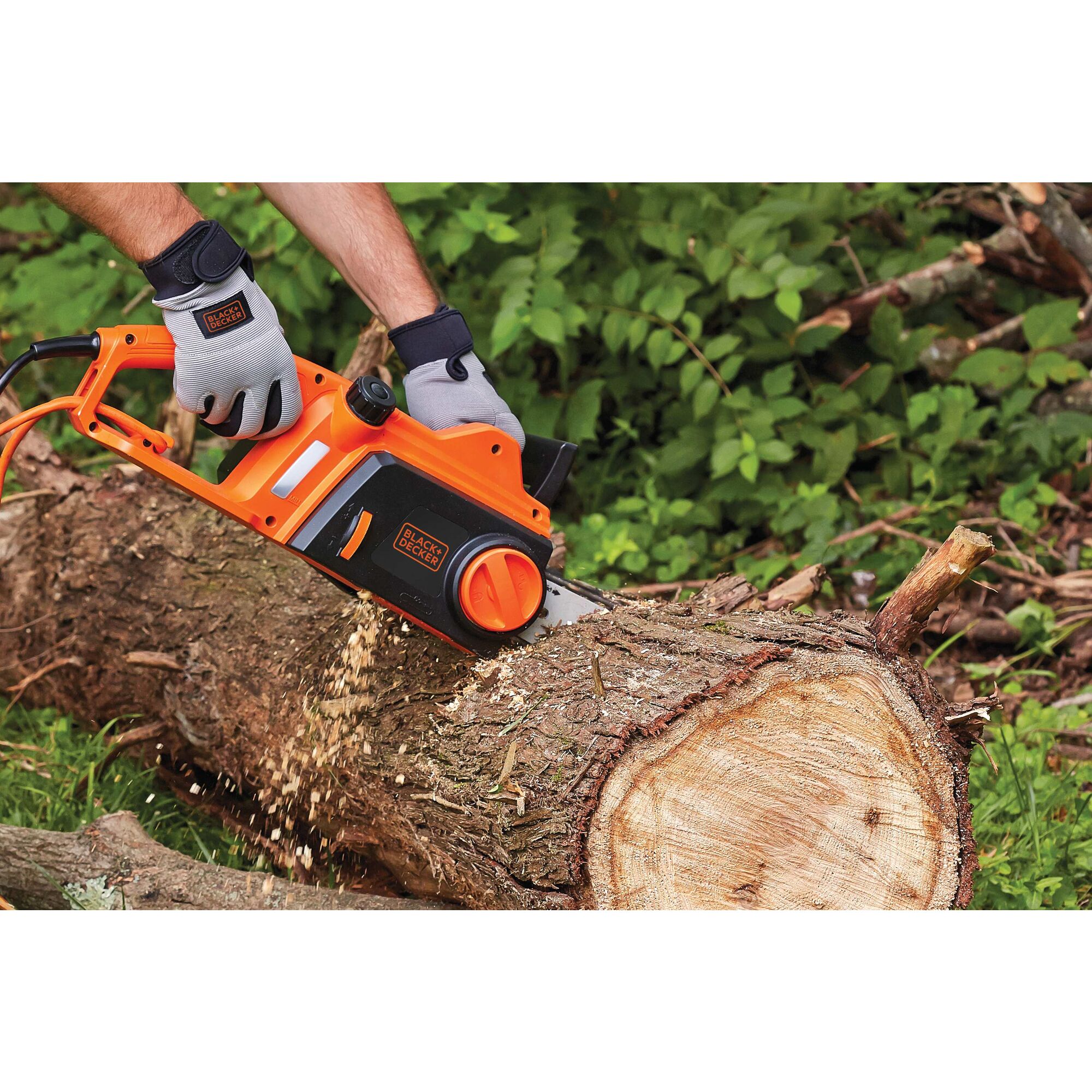 12 Ampere 16 inch chainsaw being used by a person to cut tree trunk.