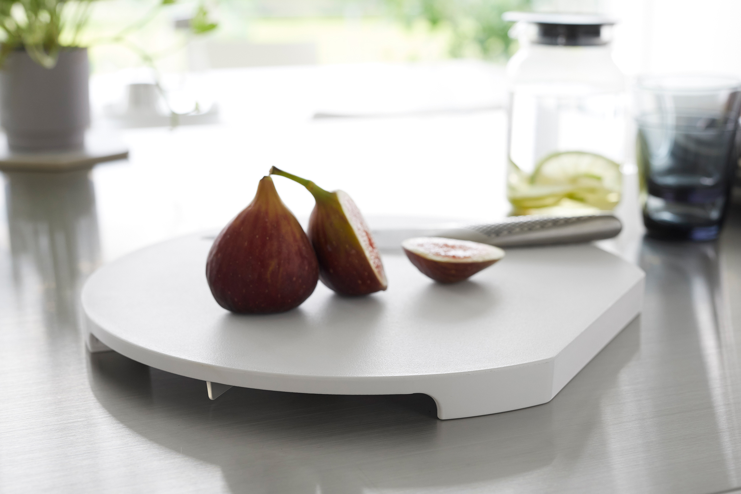 A white Yamazaki Round Magnetic Cutting Board with a fig on it.