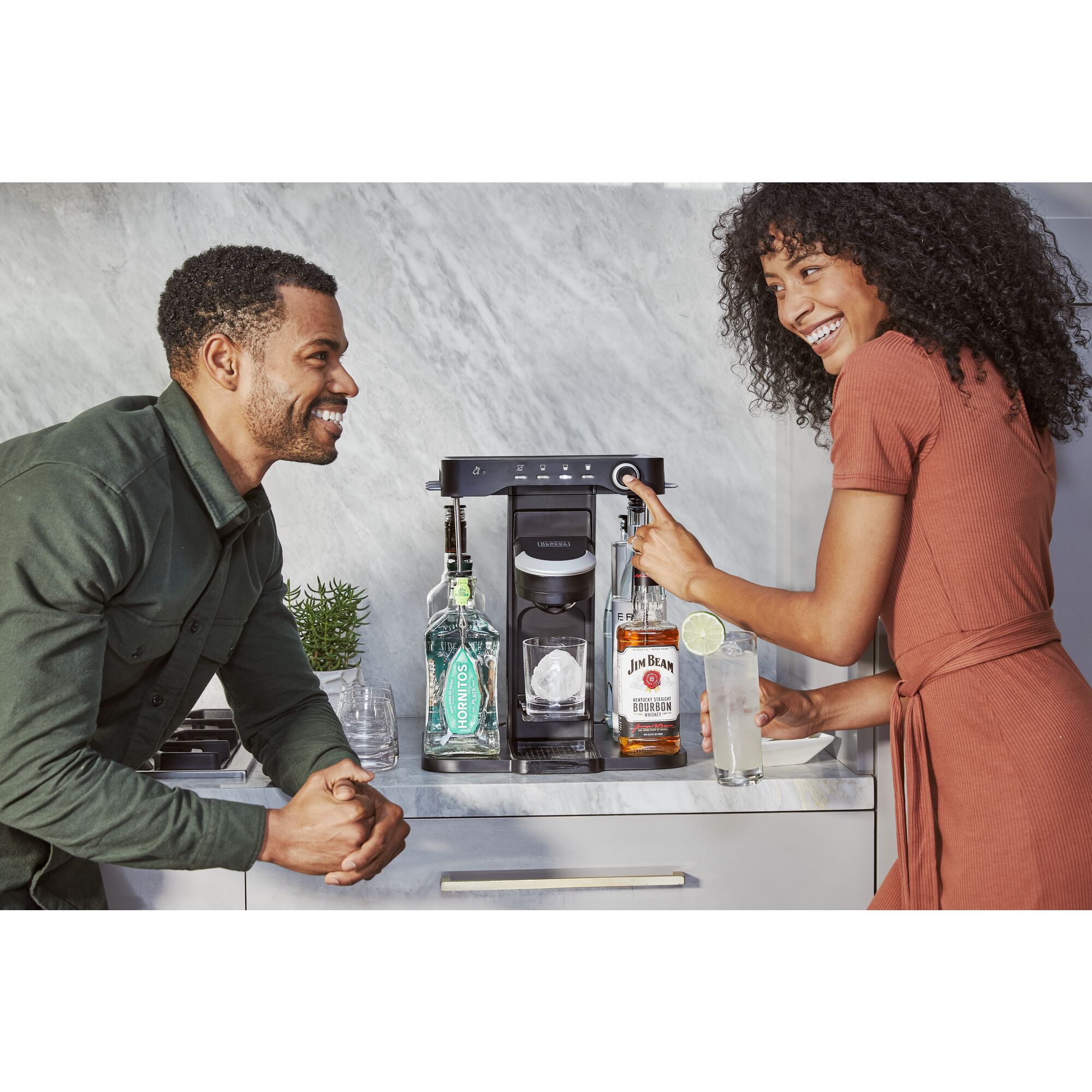 couple using the bev by BLACK+DECKER\u2122 cocktail maker to make a cocktail in the kitchen