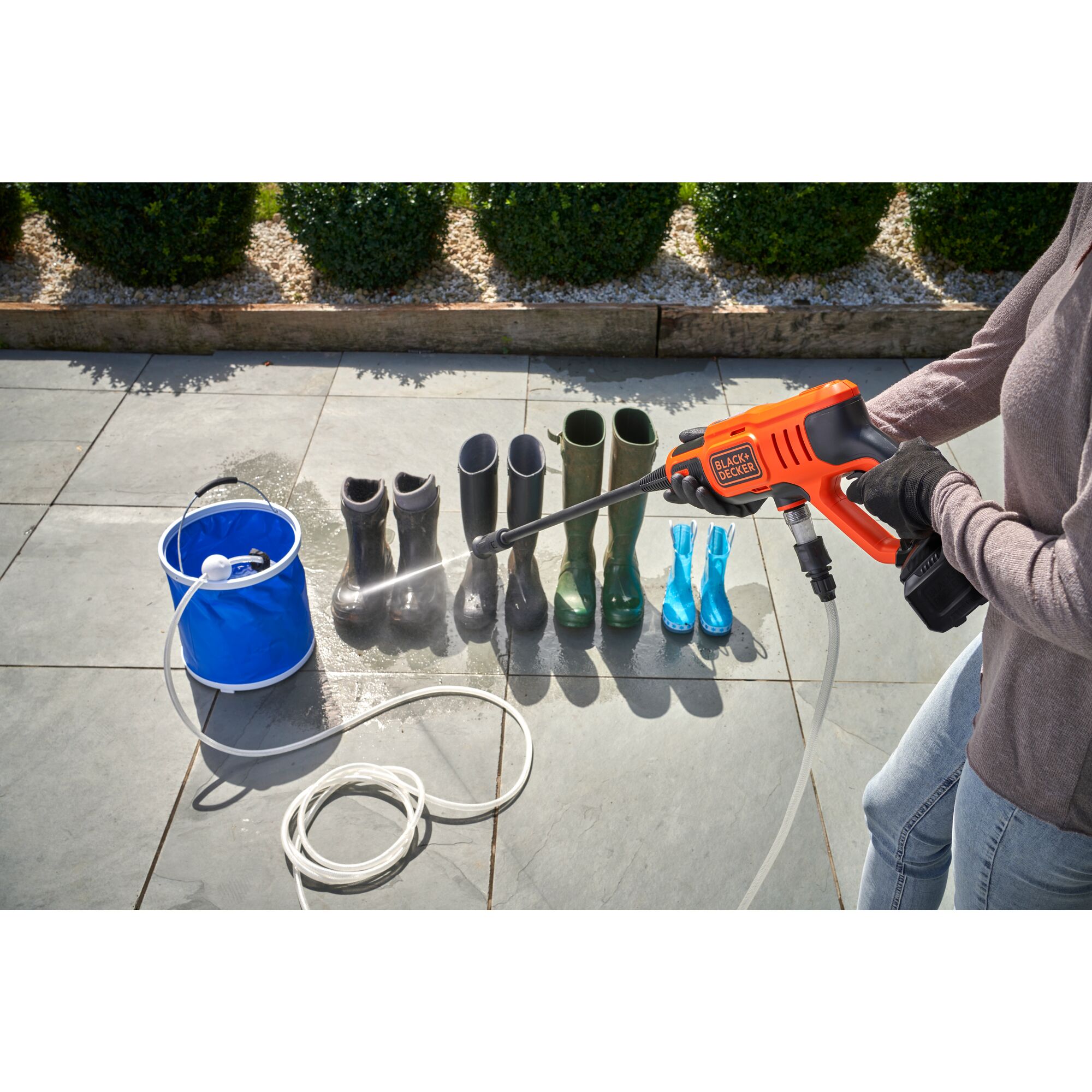 20 Volt Cordless Power Cleaner Kit being used on garden boots.
