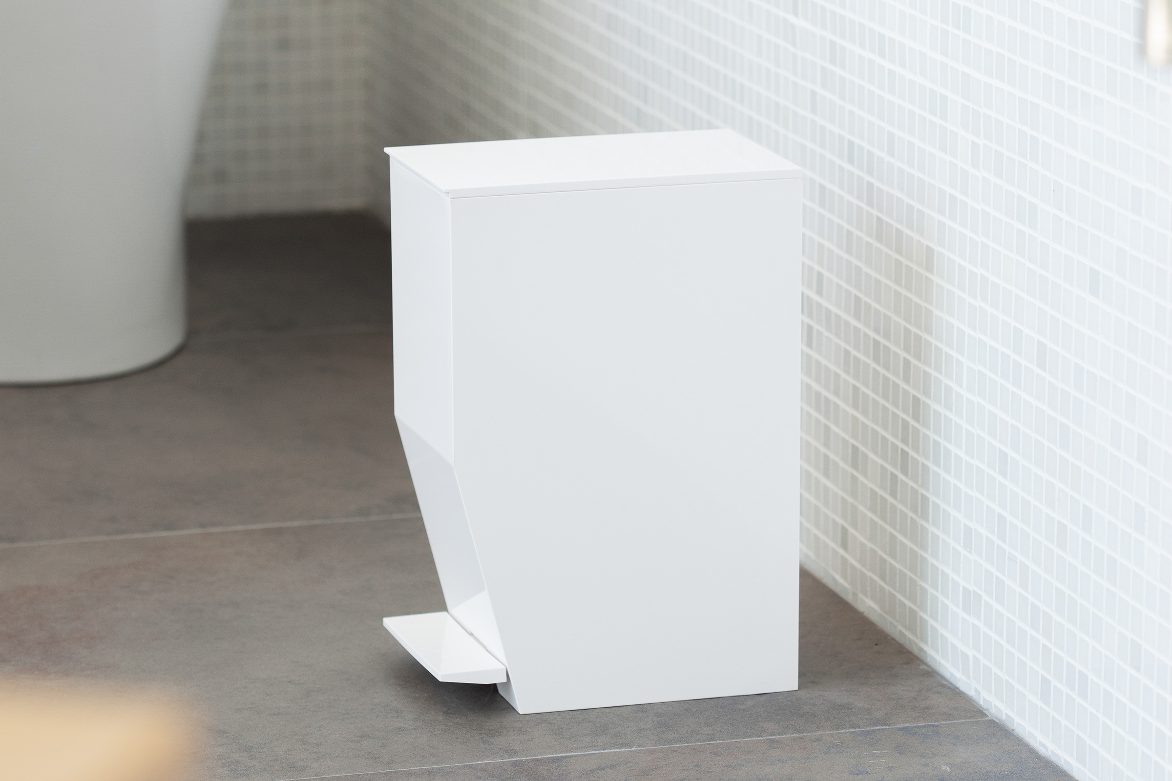 Side view of white Step Trash Can in bathroom by Yamazaki Home.