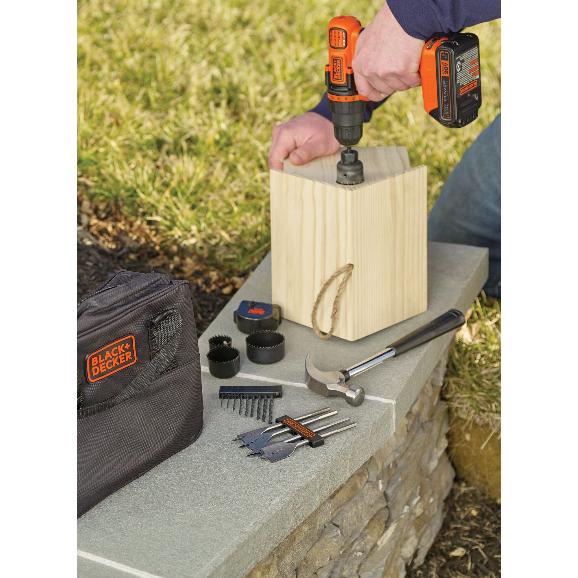 Lithium Ion Drill Driver plus 68 Piece Project Kit being used to drill hole in wooden bird house outdoors.