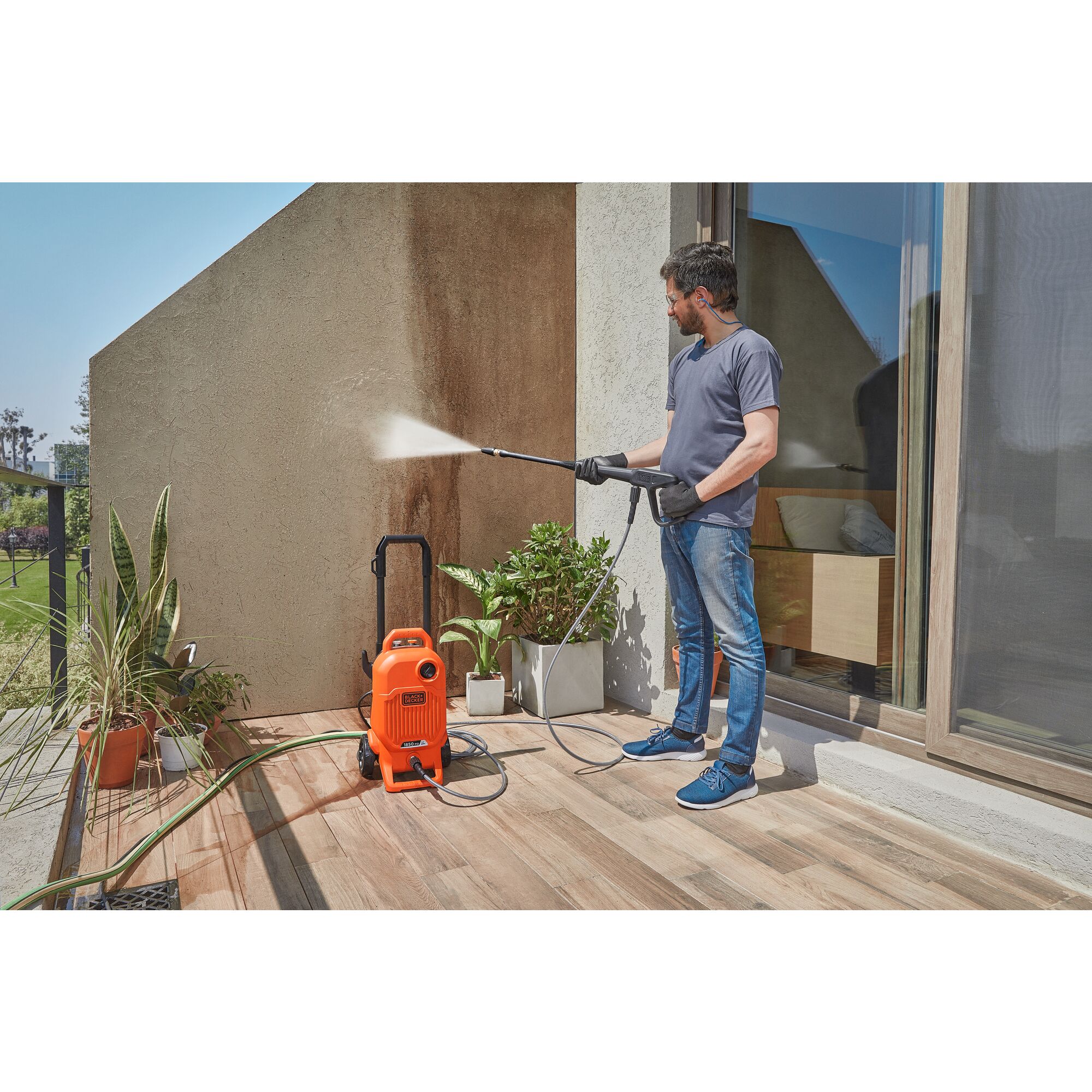 Man cleaning a porch wall with the BLACK+DECKER 1,850 MAX psi* pressure washer with turbo nozzle