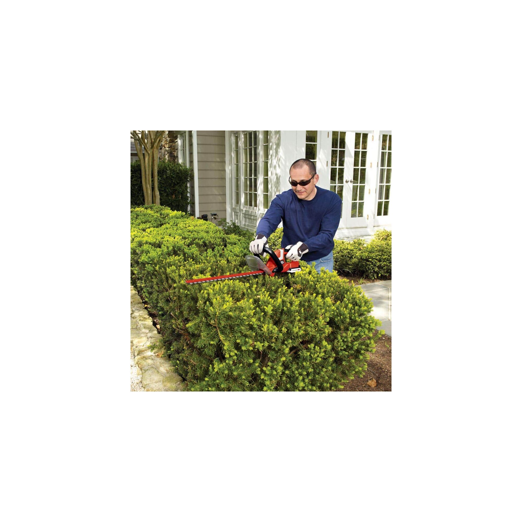 Man using BLACK+DECKER hedge trimmer on a bush