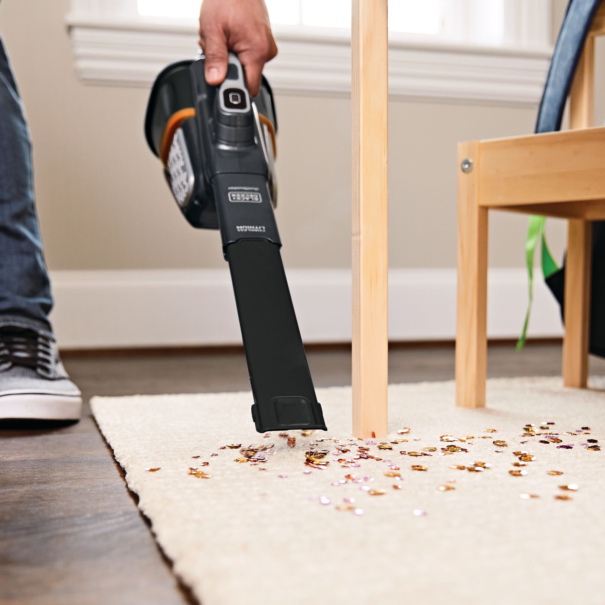 16 volt max dustbuster advanced clean plus hand vacuum being used to vacuum spilled material from a carpet.