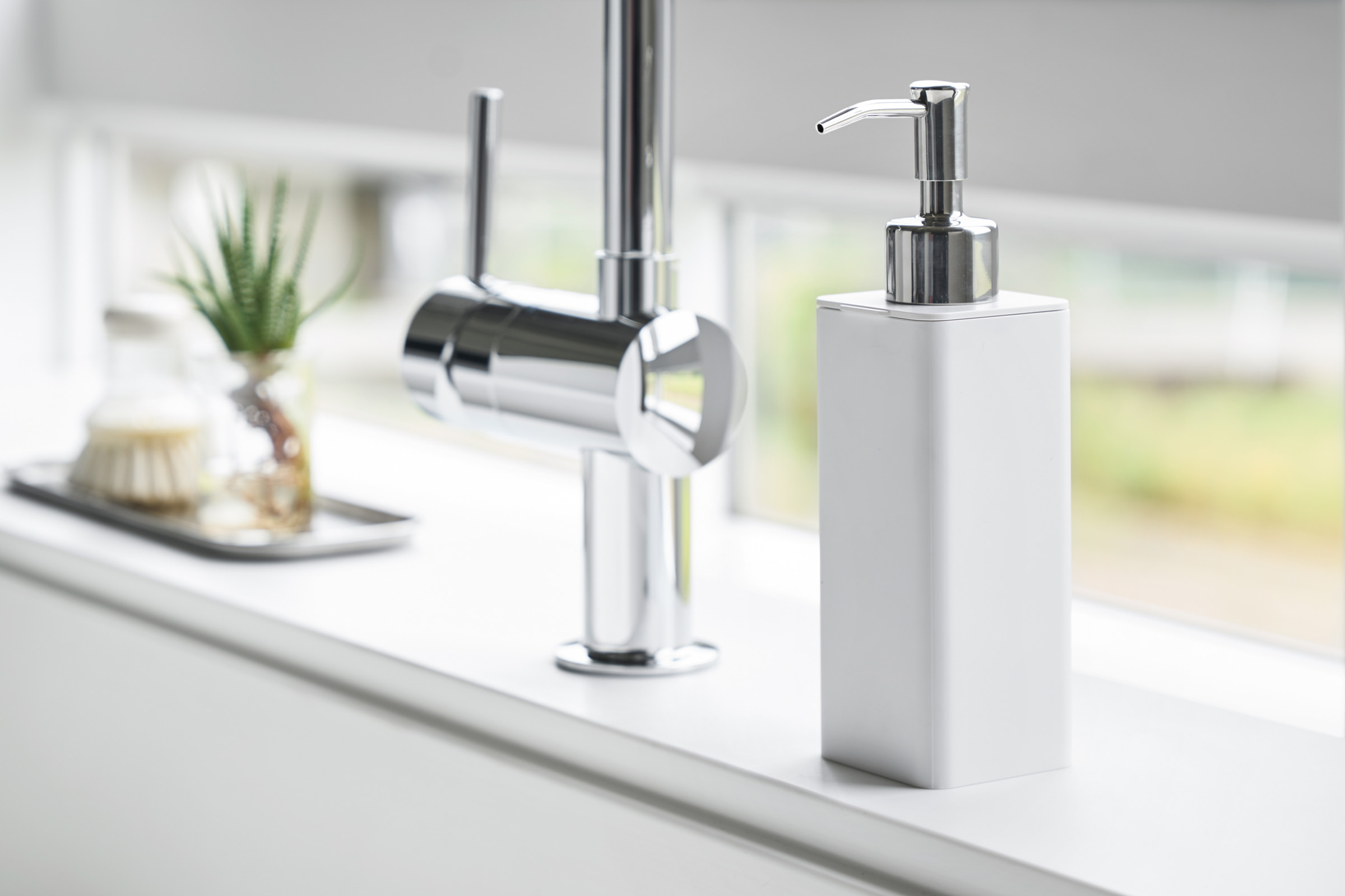 White Yamazaki Hand Soap Dispenser near a sink faucet