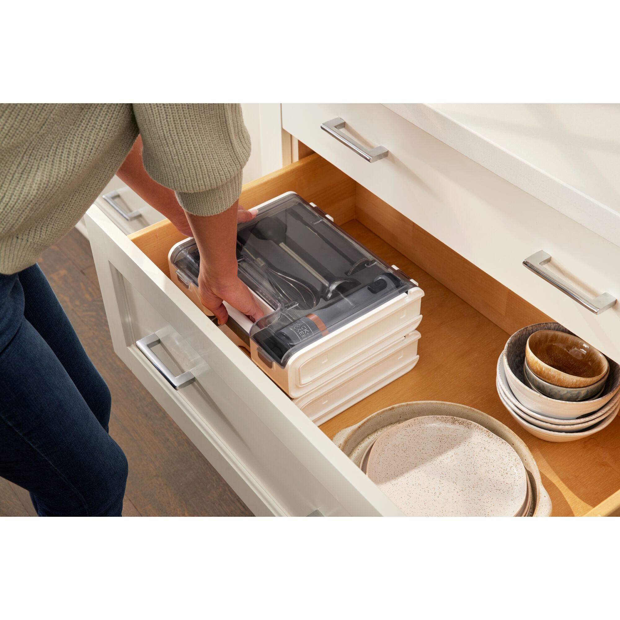 Talent reaching in to a drawer to grab the BLACK+DECKER kitchen wand storage case