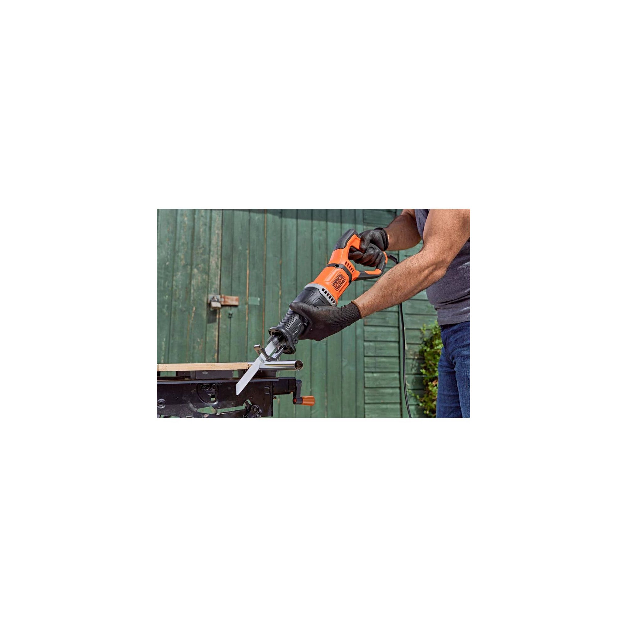 7 Amp Reciprocating Saw with Removeable Branch Holder being used to slice a metal tube by a person.