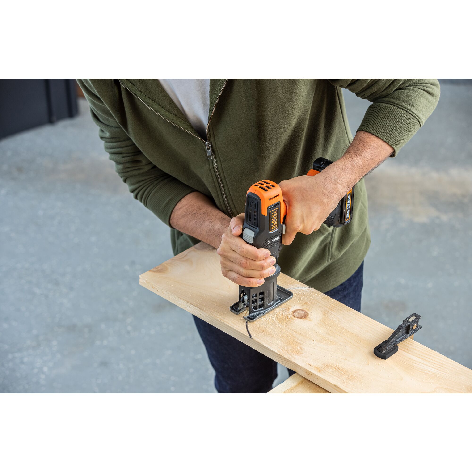 Person uses the BLACK+DECKER MATRIX jig saw attachment to cut curves in wood material