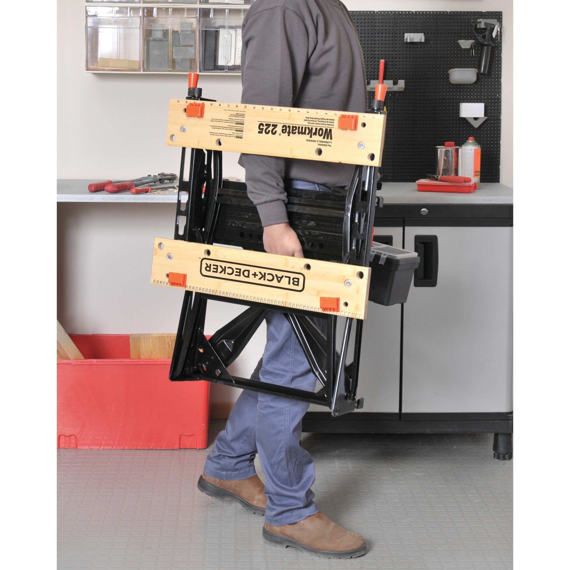 Man holding folded Workmate 225 Portable Work Center And Vise