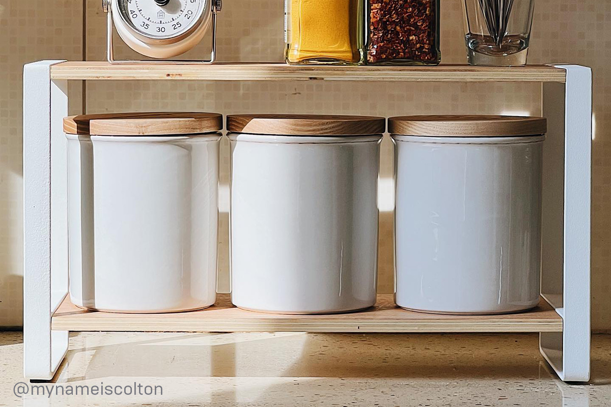 Yamazaki Home Two-Tier Riser holding canisters.