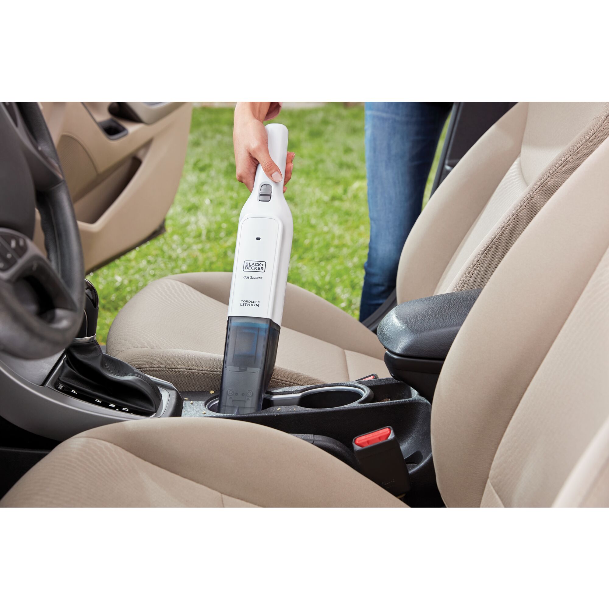 dustbuster Advanced Clean Cordless Hand Vacuum being used to clean cup holders in car.