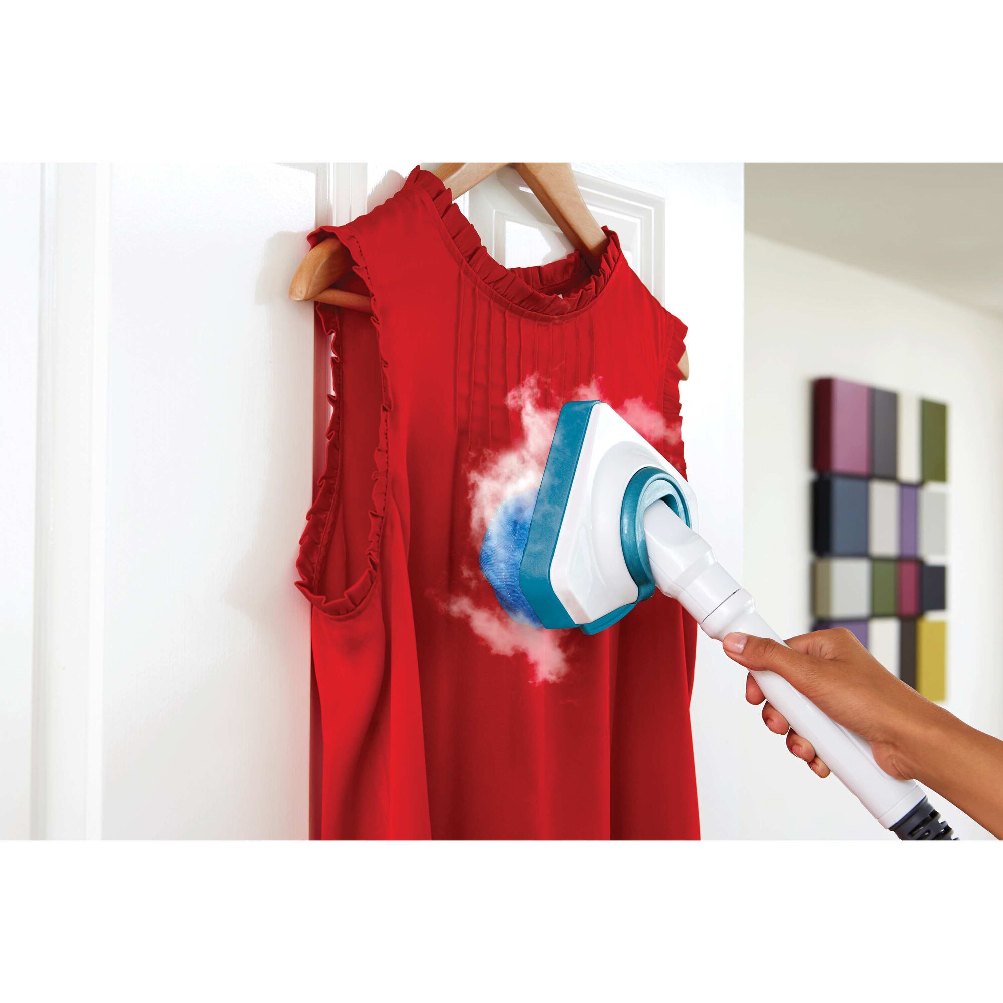 Garment attachment on the steam mop used on a red dress