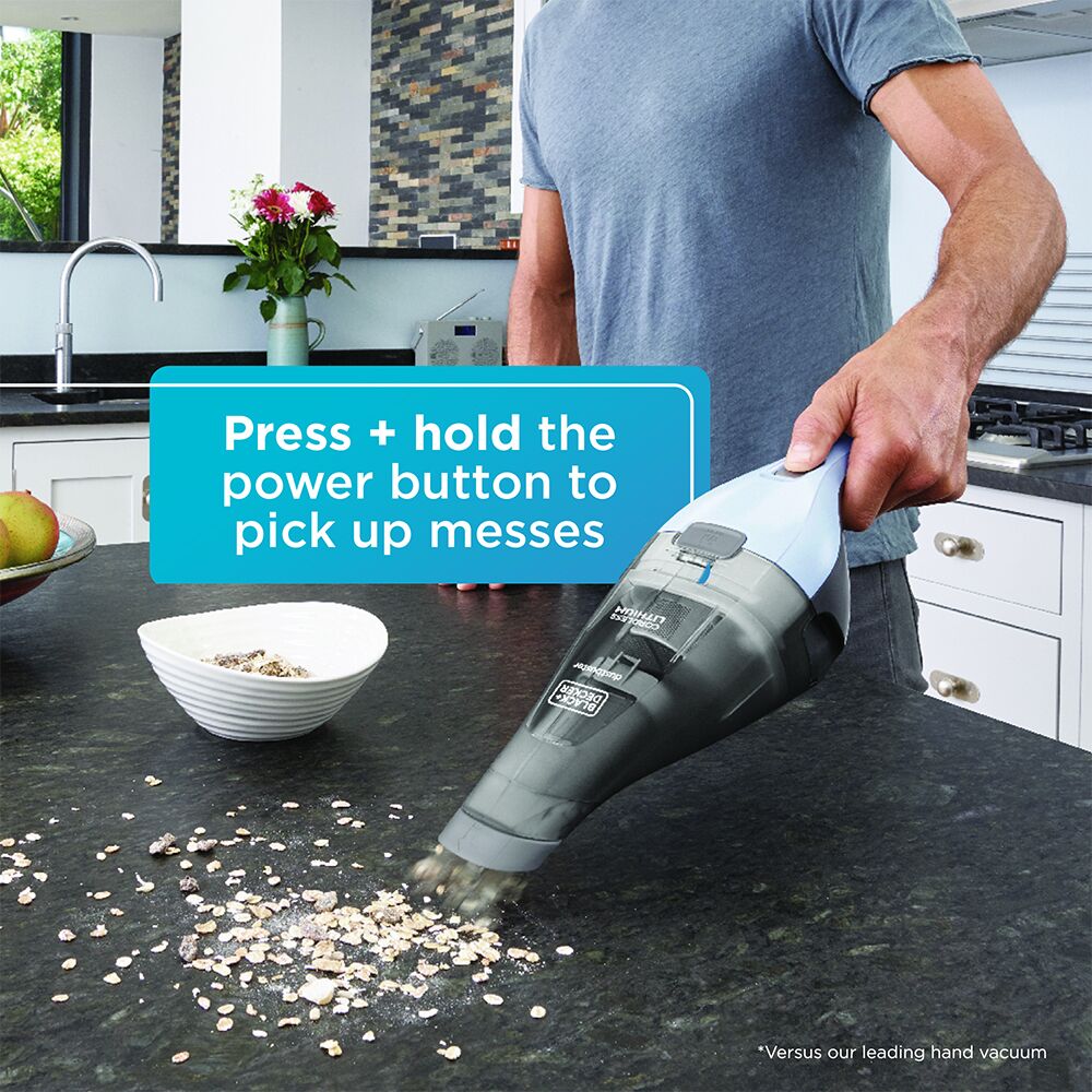 Person using HNVC215B12AEV BEYOND BY BLACK+DECKER Cordless Dustbuster - Handheld Vacuum Cleaner to clean up food: press + hold the power button to pick up messes
