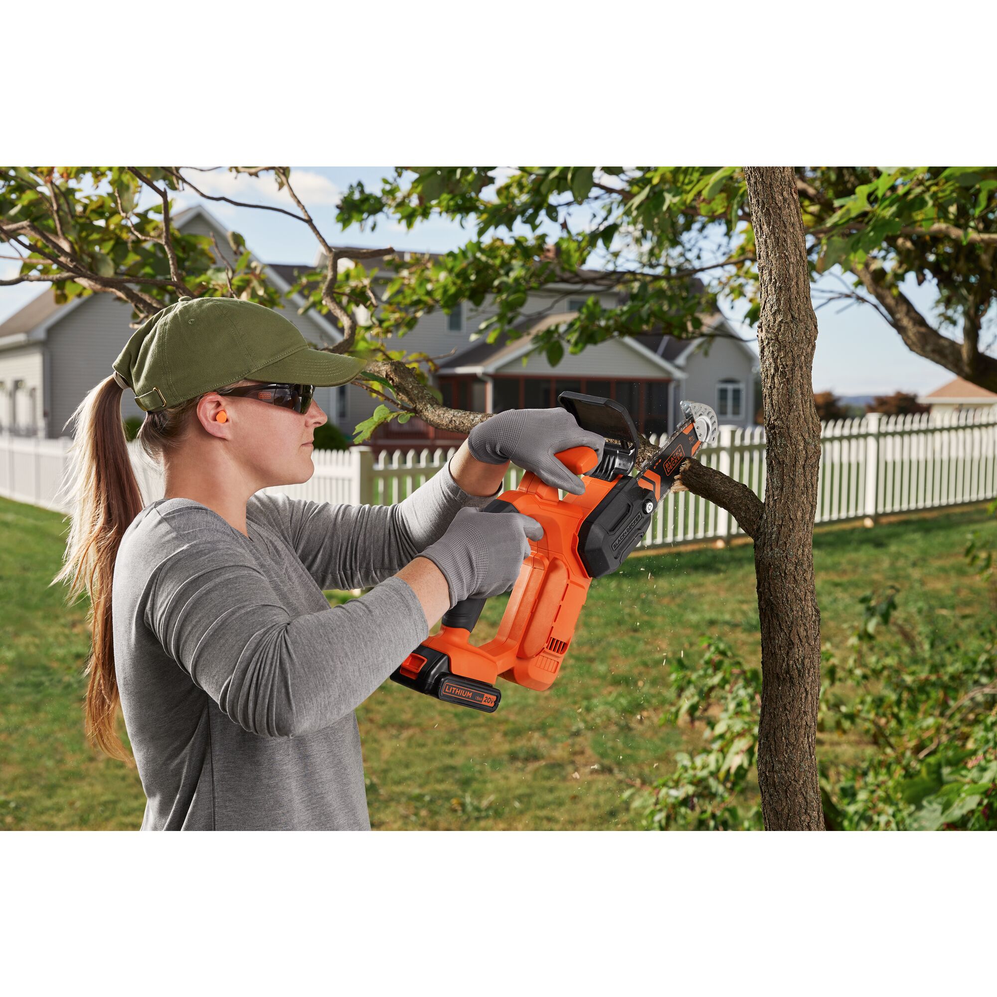 Woman using 20V Max Pruning Chainsaw on a tree outside
