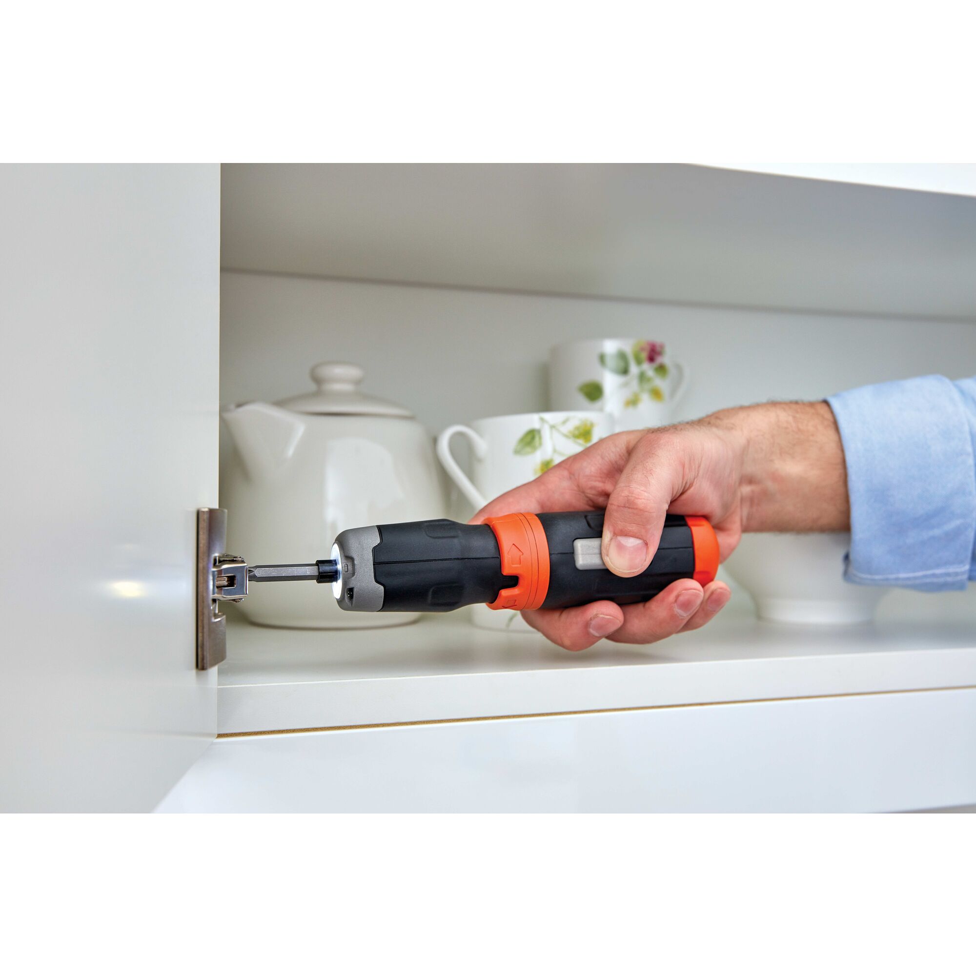 Cordless power driver screwdriver with extension shaft being used by a person.