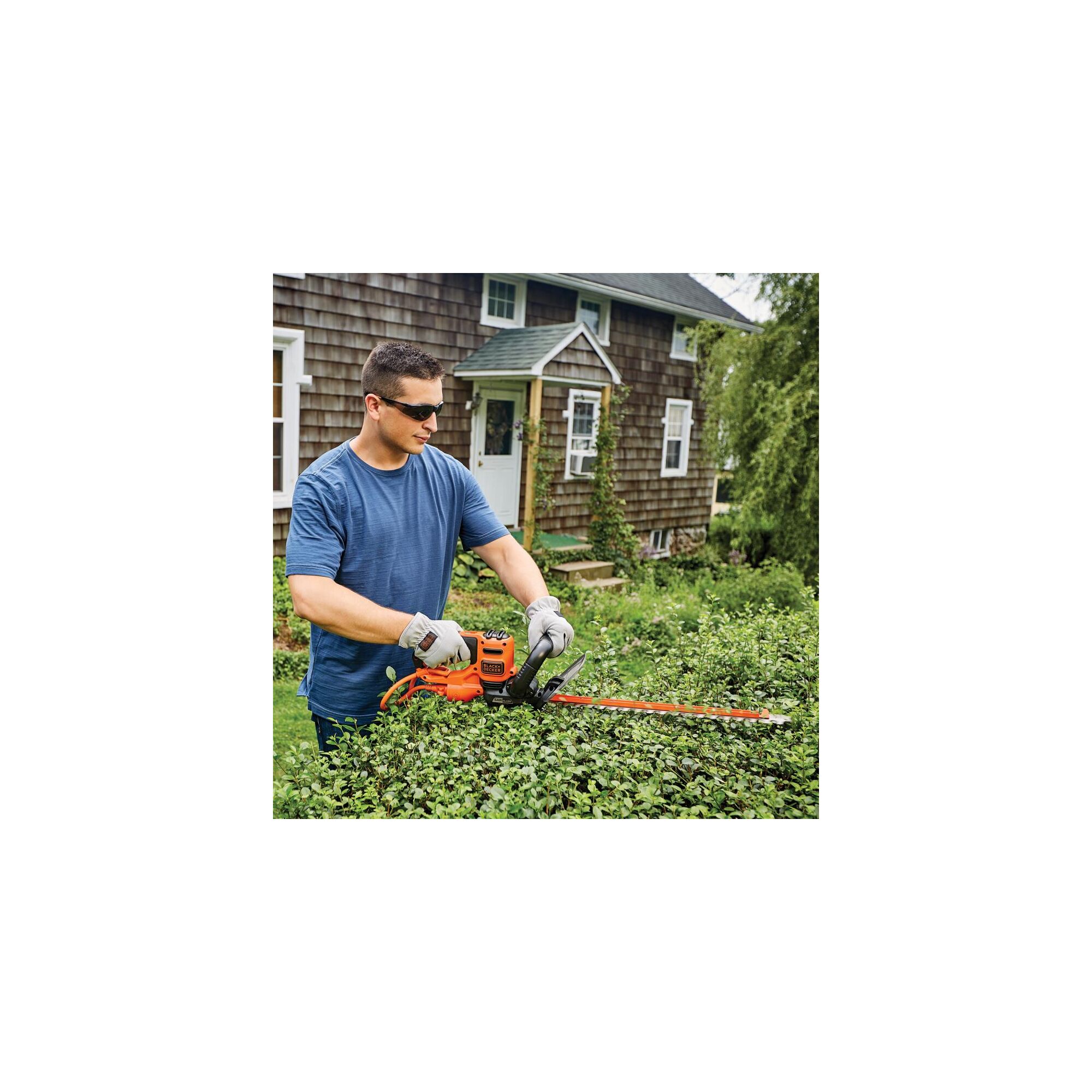 20 inch SAWBLADE electric hedge trimmer being used by a person to trim hedge.