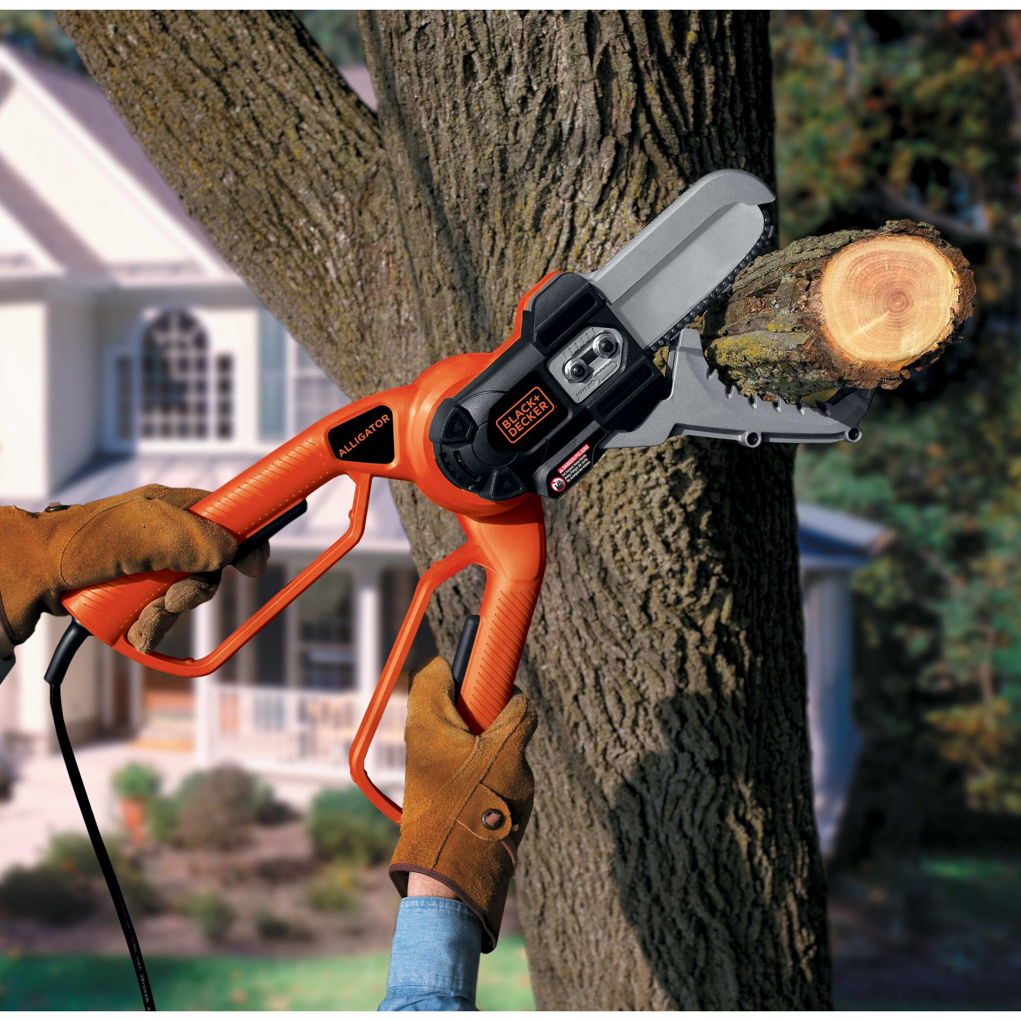 Someone using the Electric Outdoor Lopper to cut a branch from a tree.