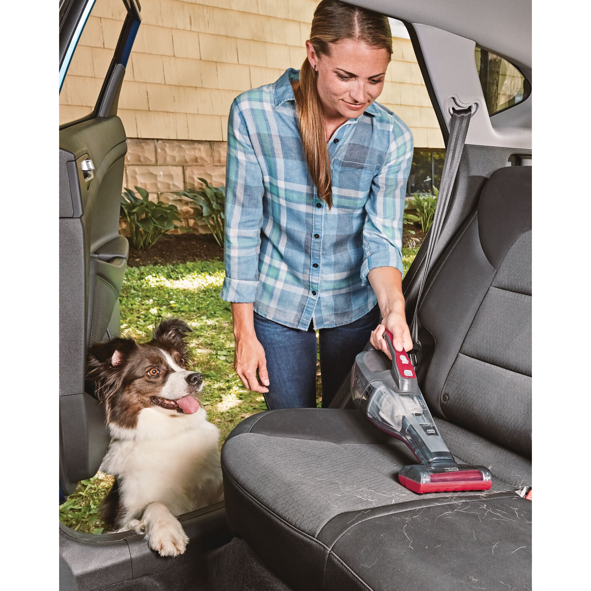 dustbuster QuickClean car cordless hand vacuum with motorized upholstery brush being used by a person to clean back seat of car.