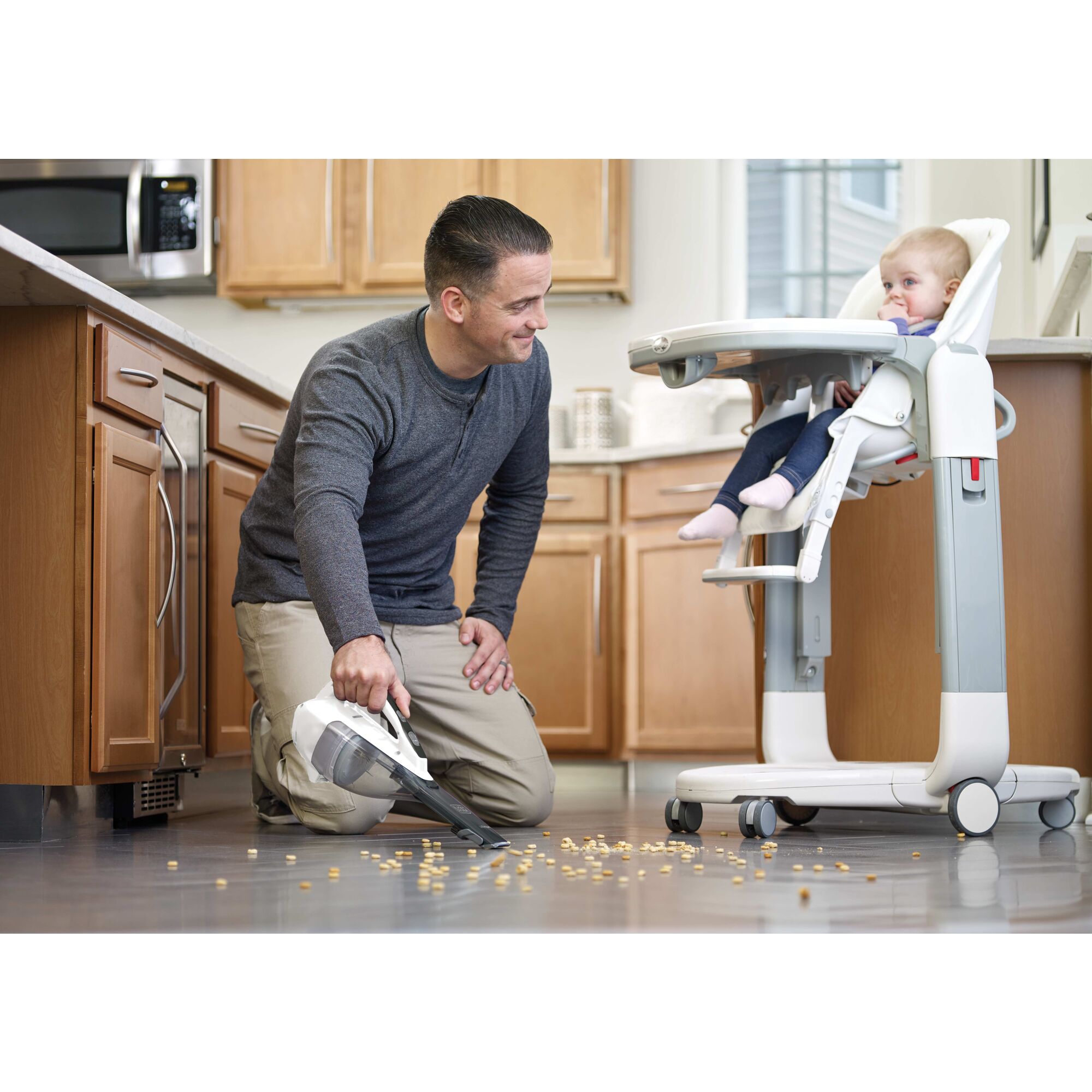 Dustbuster Advanced Clean Cordless Hand Vacuum being used for cleaning spilled bbaby food from floor.