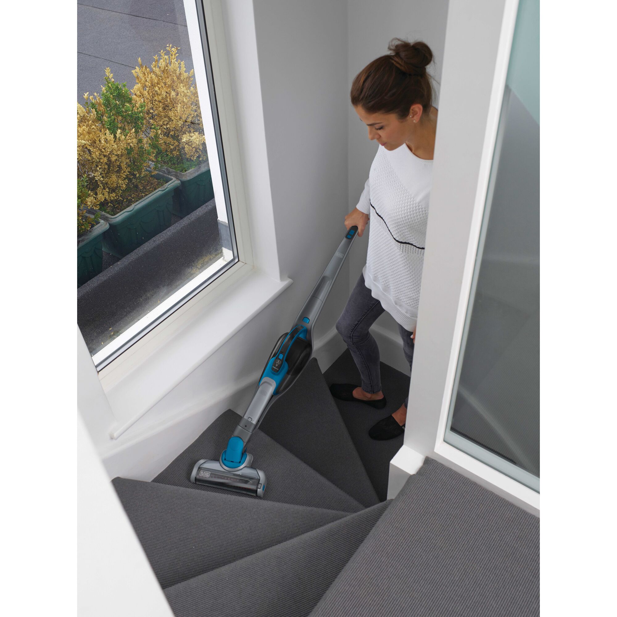 Cordless Lithium 2 in 1 Stick Vacuum being used for cleaning stairs.
