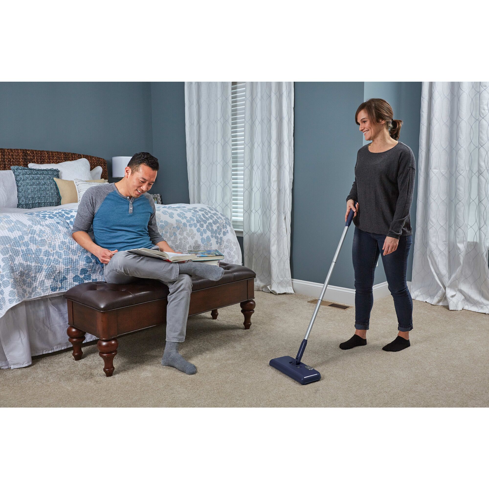 Powered Floor Sweeper being used by person to clean carpet.