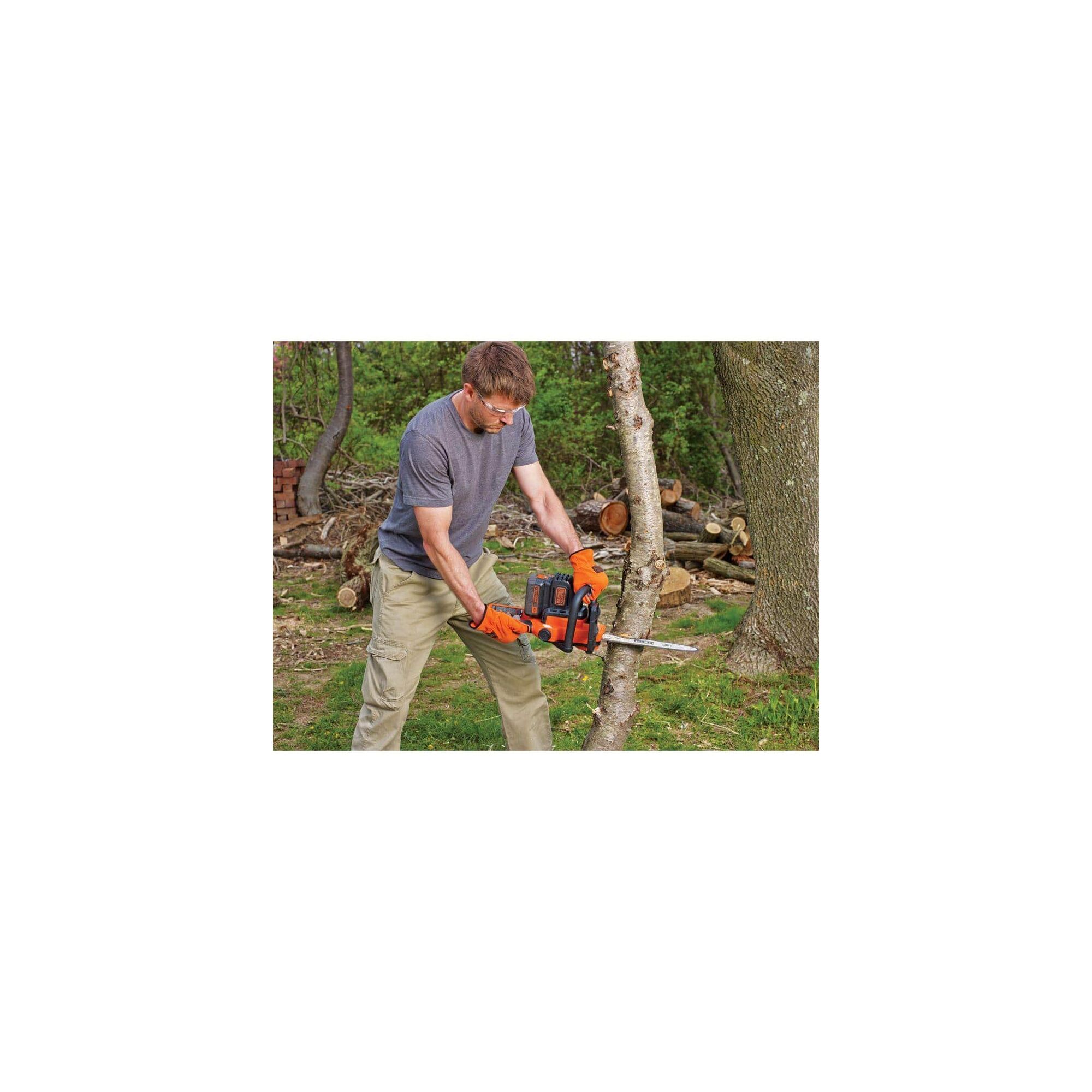 Person cutting branches with chainsaw