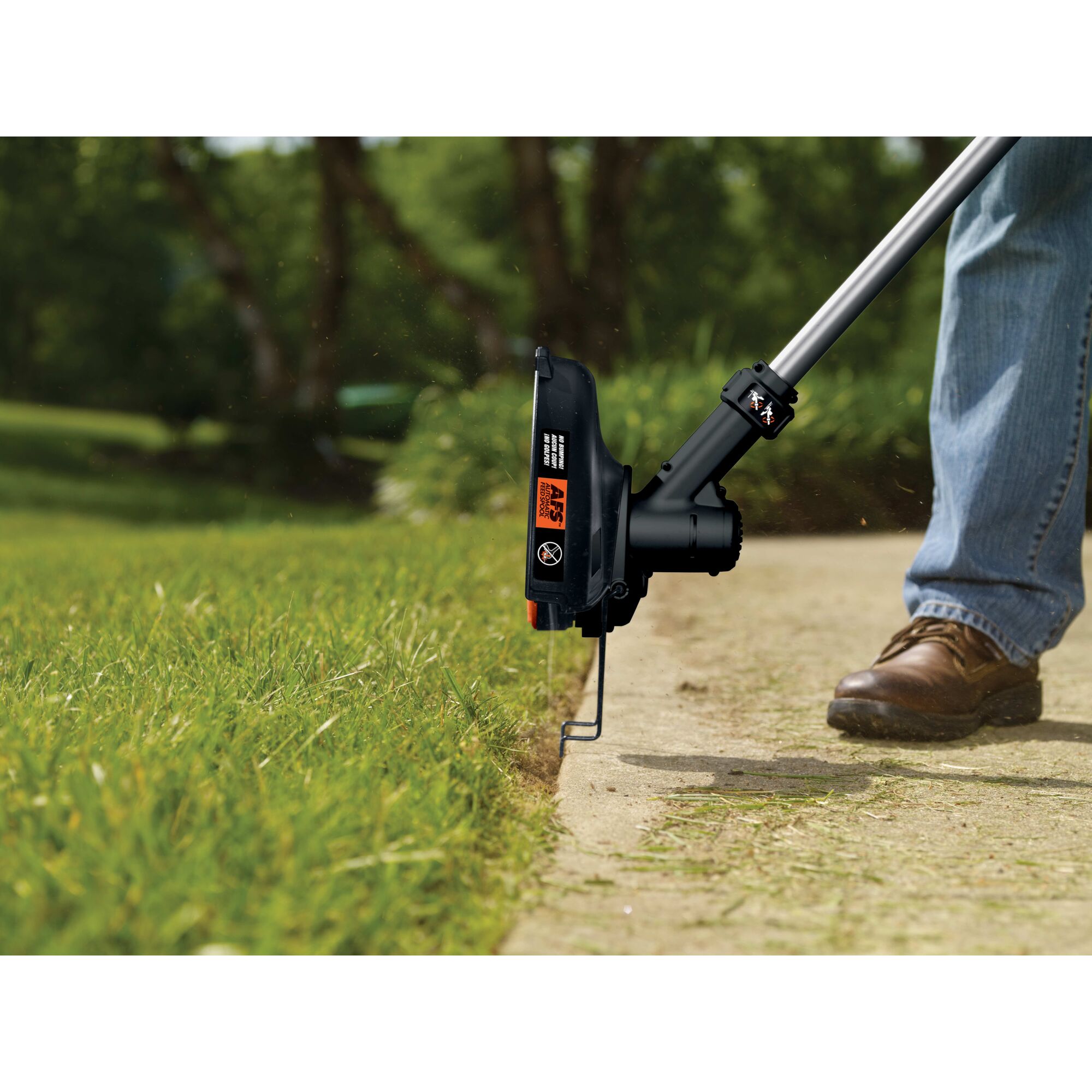 40 Volt Max String Trimmer being used to edge near a sidewalk.