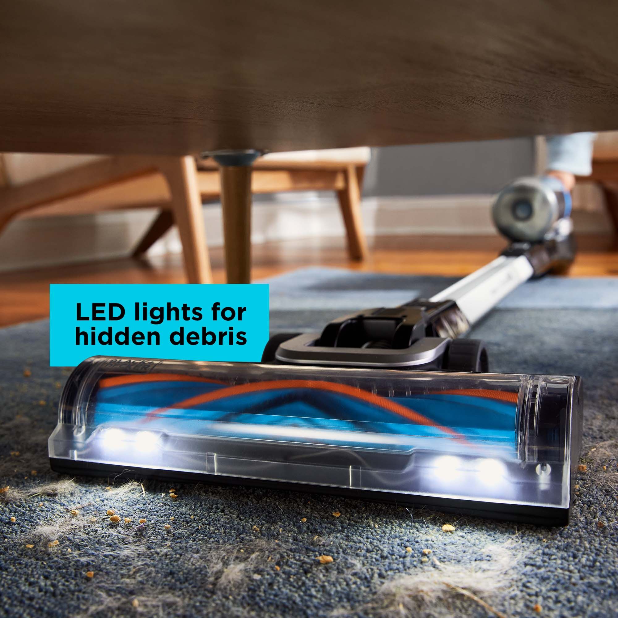 POWERSERIES Extreme MAX stick vac vacuuming under a table with the LED lights illuminating debris