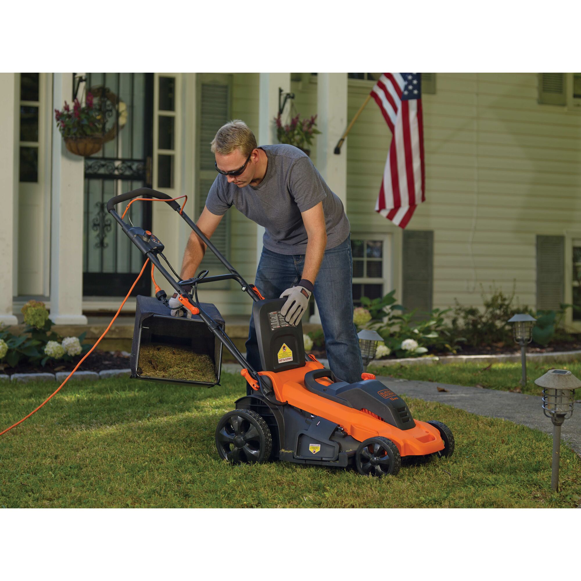 Man removing waste from Corded Lawn Mower.