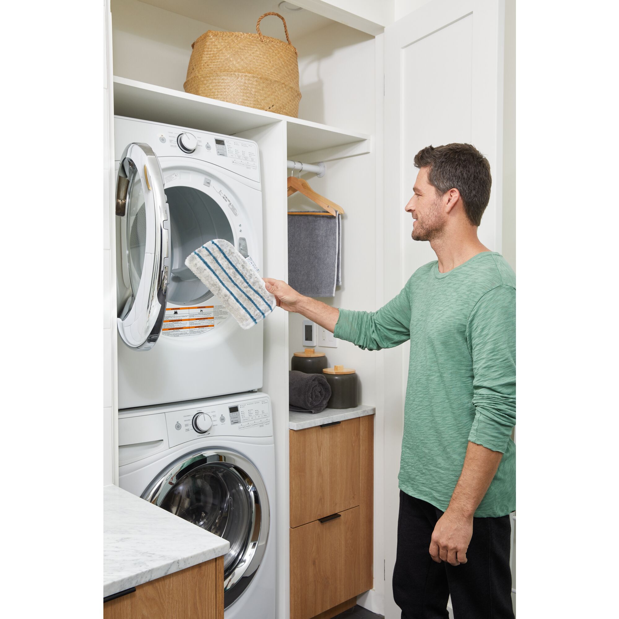 Man putting Steam-Mop™ Washable Microfiber Cleaning Pad in washing machine.