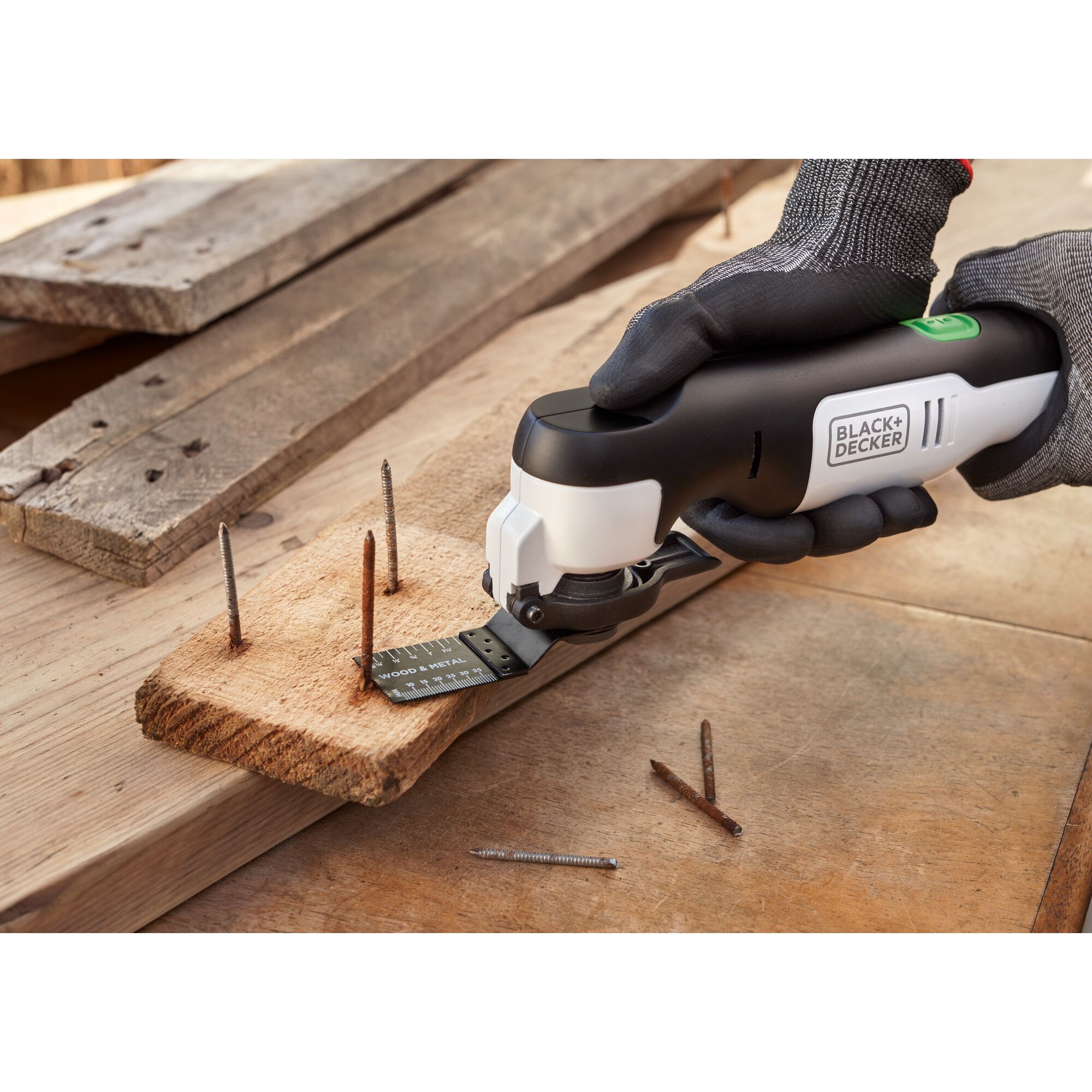reviva 12V MAX* Oscillating Multi-Tool cutting rusty nails from a wood board.