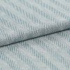 Folded woven textile with diagonal raised ribbed stripes in pale blue and white; fabric overlapped along a central fold; close-up view with soft, even lighting on a neutral surface.