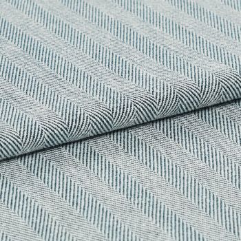 Folded woven textile with diagonal raised ribbed stripes in pale blue and white; fabric overlapped along a central fold; close-up view with soft, even lighting on a neutral surface.