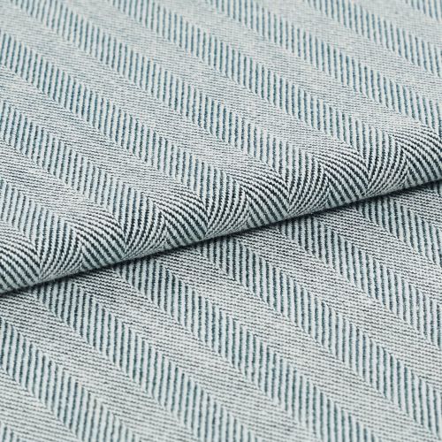 Folded woven textile with diagonal raised ribbed stripes in pale blue and white; fabric overlapped along a central fold; close-up view with soft, even lighting on a neutral surface.