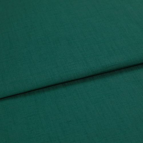 A folded teal-green woven fabric (linen texture) lies overlapping, the top edge forming a horizontal fold; close-up studio shot with even lighting and no visible background.
