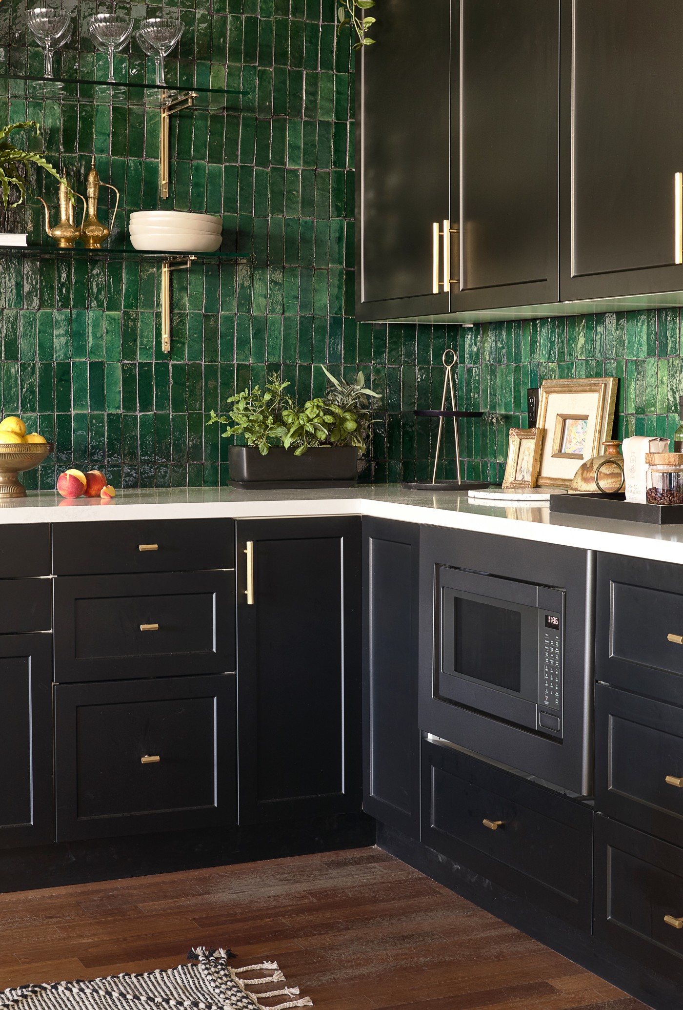 a kitchen with green tile and black cabinets.