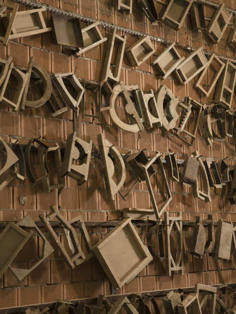 a wall full of old wooden items.