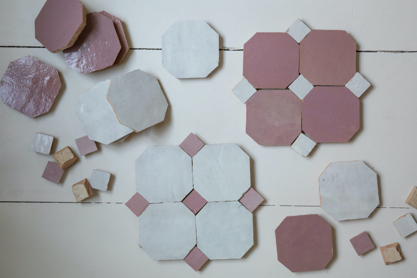 a group of pink and white tiles laid out on a white surface.