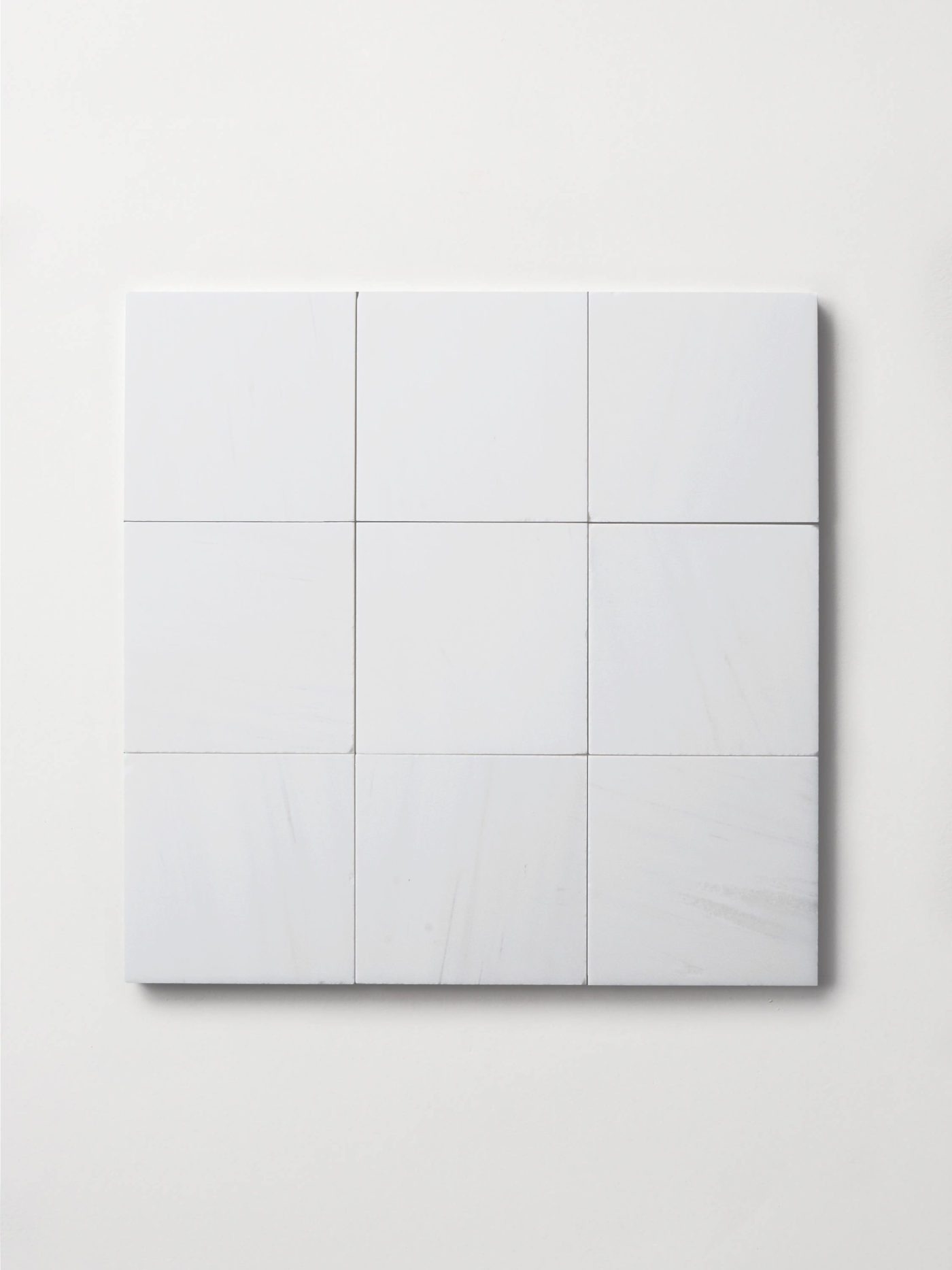 a set of square white tiles on a white surface.