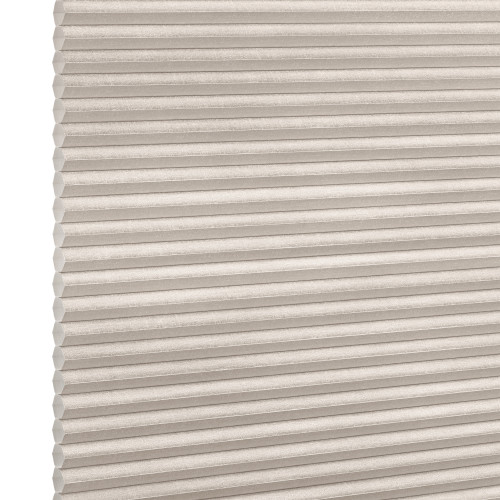 Beige cellular (honeycomb) blind, horizontal pleats with visible hexagonal cells at left edge; closed and diffusing light; photographed in a neutral, evenly lit studio setting with no visible room.