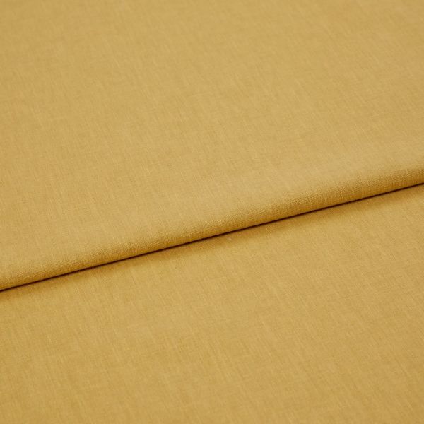 Mustard-yellow woven fabric panel, folded once with a visible overlapping edge, lying flat and smooth; close-up, studio-lit view emphasizing fine textile texture and warm, even lighting.