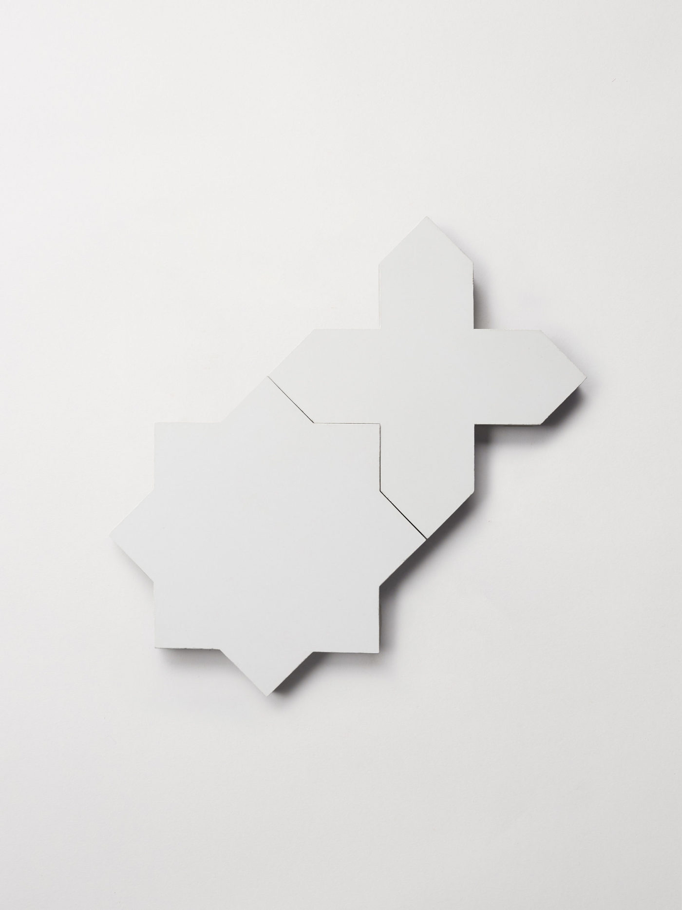 a set of white star and cross-shaped tiles on a white background.