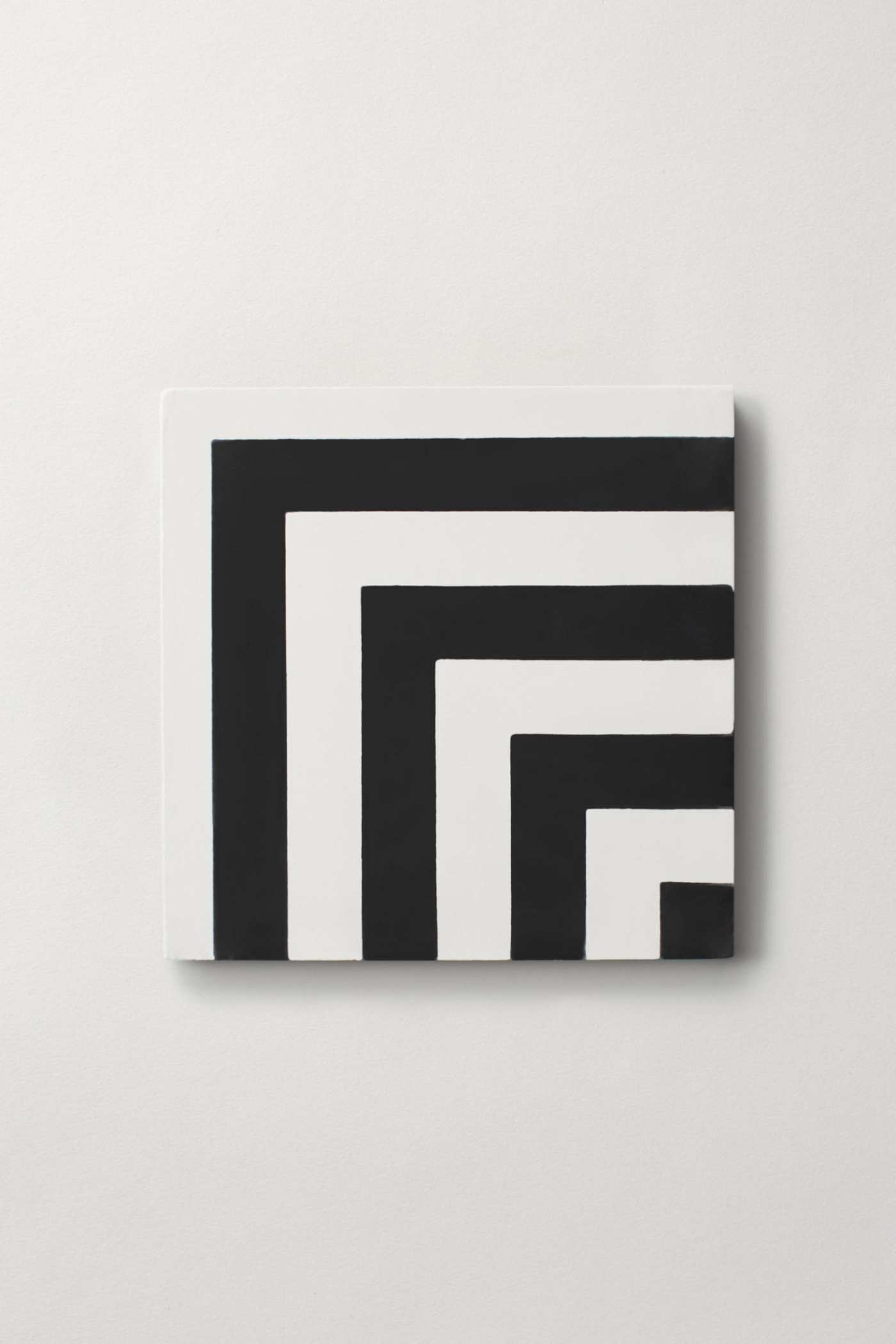 a black and white square tile on a white surface.