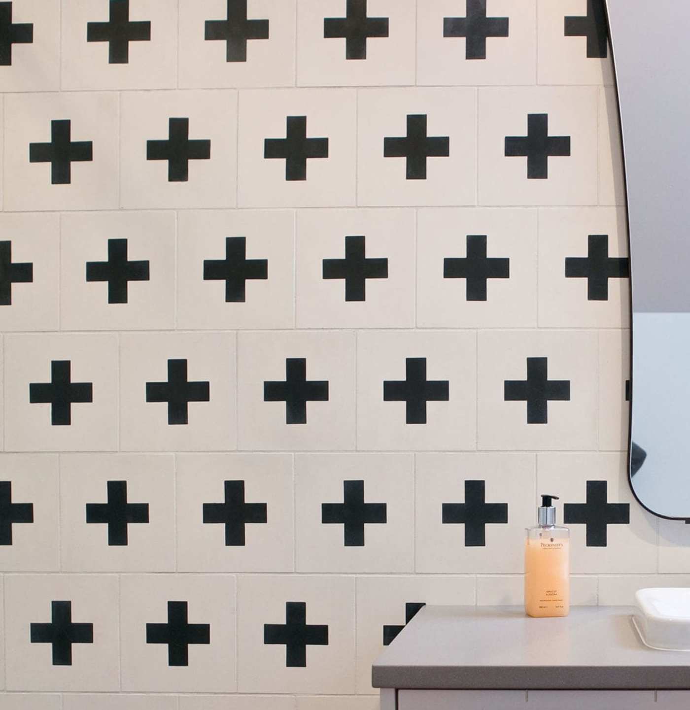 a bathroom with a black and white tiled wall.