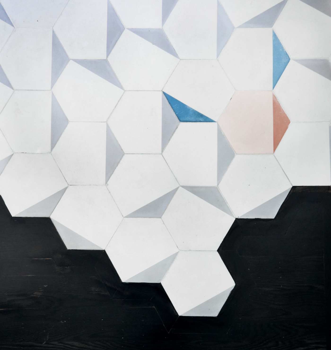 a white tile wall with blue and white hexagons.